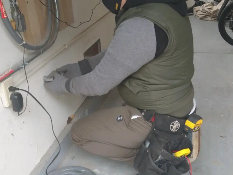 Electrician performing outlet wiring in a Mount Holly garage